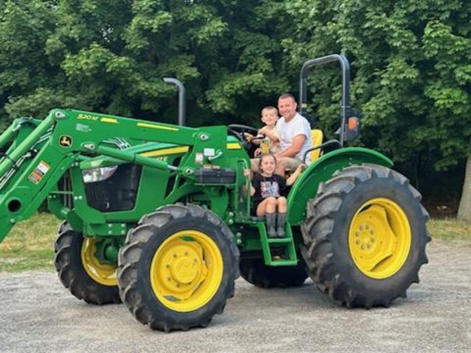 Family on a green farm tractor